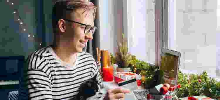 Man with cat online shopping with credit card at Christmas time