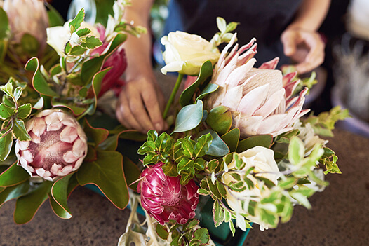 Person's hand completing a flower arrangement