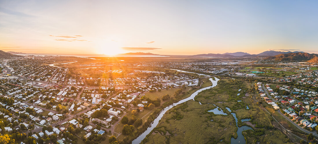 birds eye view of the Brisbane skyline at dusk, header image for the top 10 suburbs for first home buyers article.